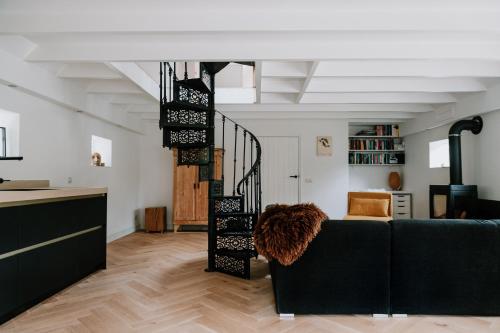a living room with a couch and a spiral staircase at De Vijf Suites in Elp