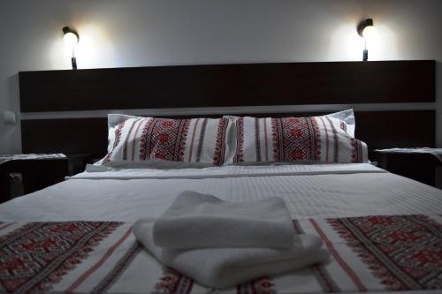 a bedroom with a bed with two pillows and a white bedspread at Casa Lia in Valea Putnei