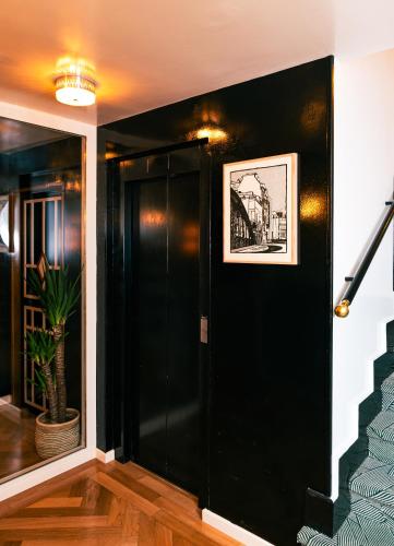 a black door in a hallway with a staircase at Hotel du Temps Madrid in Madrid