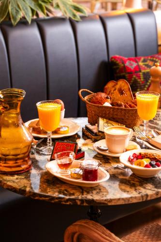 a table with plates of food and glasses of orange juice at Hotel du Temps Madrid in Madrid