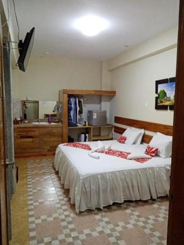 a bedroom with a large bed and a sink at Casa Nativa Iquitos in Iquitos