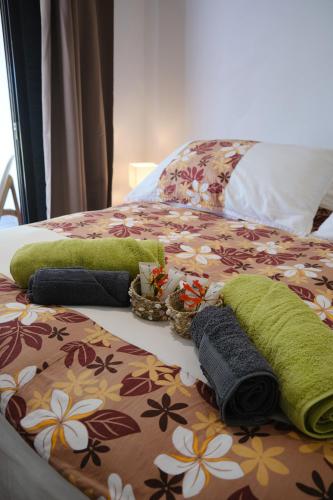 a bed with blankets and pillows on it at Villa Te Torea in Arue