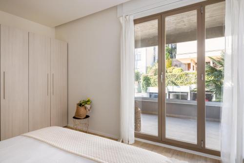 a bedroom with a bed and a sliding glass door at Family Joy - Close to city centre in Lugano