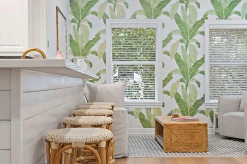 a living room with a couch and stools at The Palm Beach House - Tropical in Palm Beach