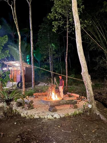 a man standing around a camp fire at night at Lainkalogos Glamping in Rabia