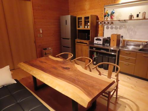 a kitchen with a wooden table in a kitchen at 修善寺テラスヴィラ バレルサウナ付アウトドアリゾート in Izu