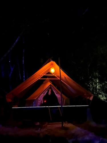 a tent with a light in the dark at Lainkalogos Glamping in Rabia