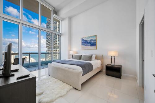 a bedroom with a bed and a desk and windows at Icon Brickell Residences in Miami