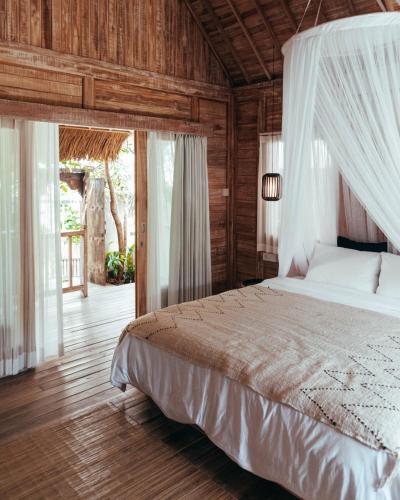 a bedroom with a bed with a canopy at Sampian Cottages Bingin in Uluwatu