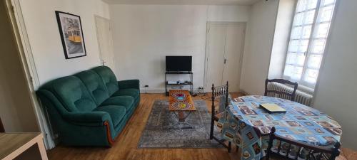 un salon avec un canapé vert et une table dans l'établissement Saint Eloi habitat, à Crocq