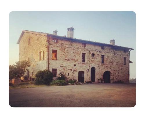 an old stone building with two chimneys on top at B&B Il Tempo Ritrovato in Canossa