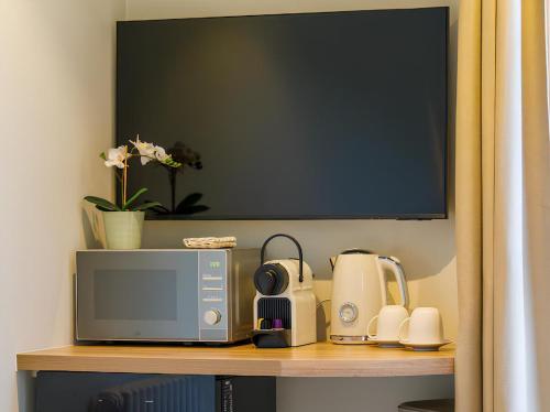 un micro-ondes posé sur une étagère avec un micro-ondes dans l'établissement Cosy Studio, à Trouville-sur-Mer