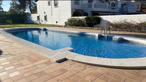 マラガにあるFantástico apartamento con piscina comunitaria junto al mar en Málagaの建物の前の青い水のプール