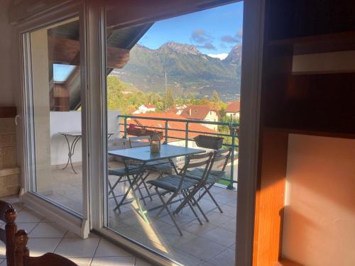 une vue d'un balcon avec une table et des chaises dans l'établissement appartement la tournette, à Saint-Jorioz