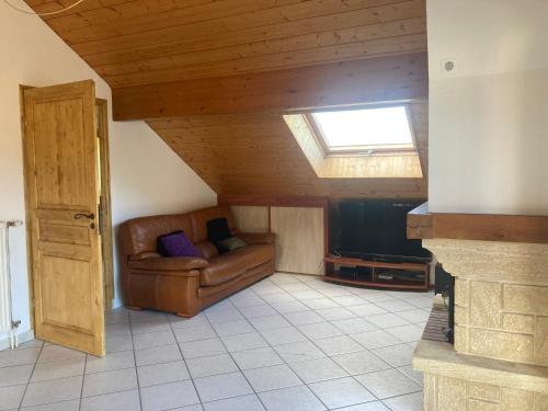 un salon avec un canapé et une télévision dans l'établissement appartement la tournette, à Saint-Jorioz