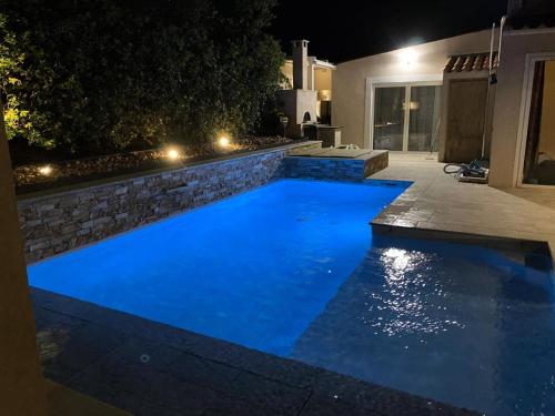 - une piscine d'eau bleue la nuit dans l'établissement Résidence Bastide - Magnifique maison a 200m de la mer avec piscine privée spa et terrain de pétanque MAE-5901, à Six-Fours-les-Plages
