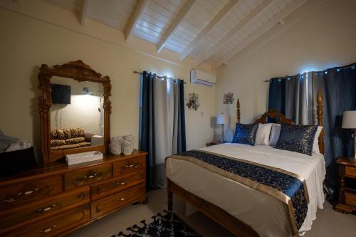 a bedroom with a bed and a mirror and a dresser at Sunset Brooke Retreat in Falmouth