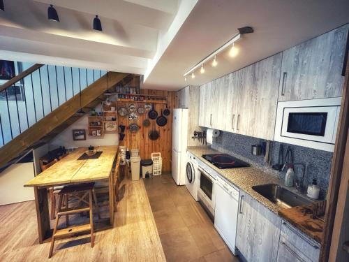 a kitchen with wooden cabinets and a wooden counter top at La casa Pedalejo in Benasque