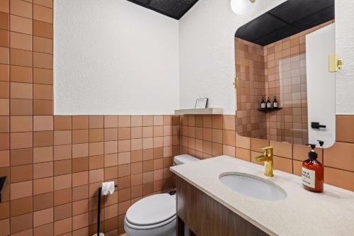 a bathroom with a toilet and a sink at Arka Motel in Rogers