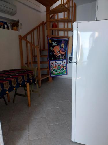 a kitchen with a white refrigerator and a staircase at La luna in pesci in Biassa