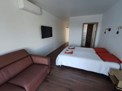 a hotel room with a bed and a couch at L 'ancienne vigne by hd - Gîte & Spa in Saint-Clair