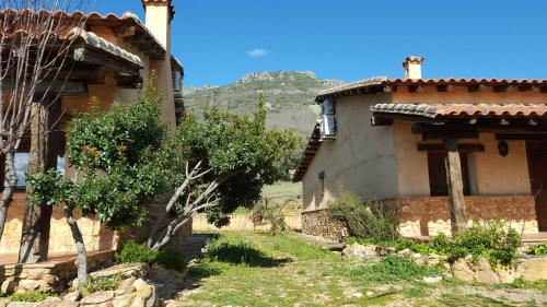 a house with a mountain in the background at Apartamentos Rurales En Plena Sierra in La Calera