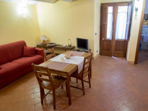 マッサ・ルブレンセにあるCasa Vacanze Massa Lubrenseのリビングルーム(テーブル、赤いソファ付)