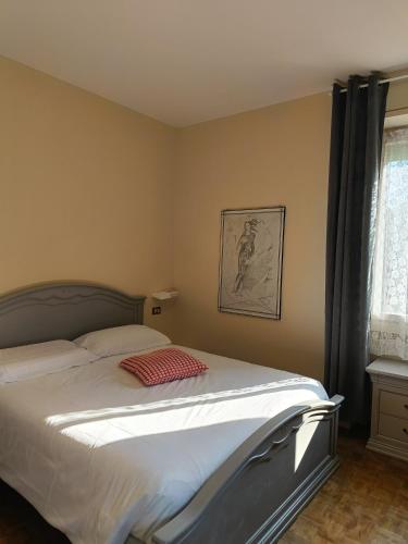 a bedroom with a bed with a red pillow on it at Gardalba in Toscolano Maderno