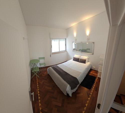 a bedroom with a large bed and a window at CARCAROOMS Guest House in Carcavelos