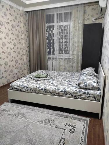a bedroom with a bed and a window at Sun elit in Bishkek