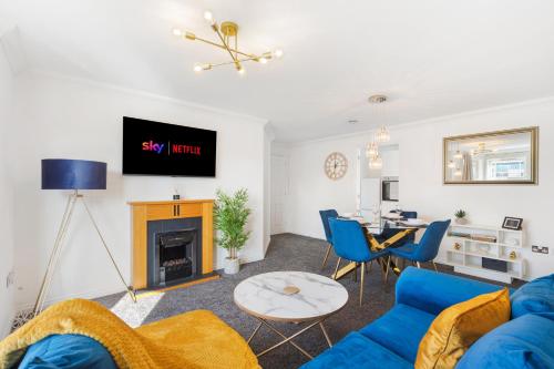 a living room with a blue couch and a table at Deluxe 2-Bedroom Serviced Apartment near Windsor Castle & M4 - Free Parking in Windsor