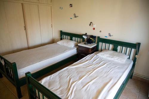 two twin beds in a bedroom with a nightstand and a bed sidx sidx sidx at Ouzaki House in Antipata