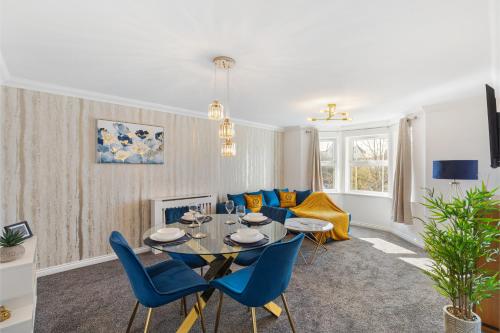 a living room with a table and blue chairs at Deluxe 2-Bedroom Serviced Apartment near Windsor Castle & M4 - Free Parking in Windsor