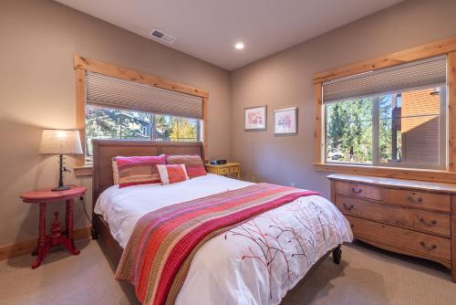 a bedroom with a bed and a dresser and two windows at Deluxe Truckee Townhome 3BDR Dog Friendly Great Location in Truckee