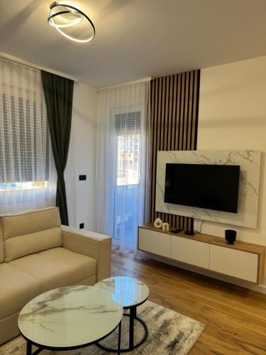a living room with a couch and a flat screen tv at Julie Apartment Sarajevo in Donje Mladice