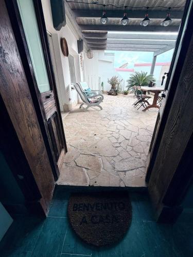 an open door to a patio with a rug in the doorway at Luxury Pisu Apartments in Quartucciu