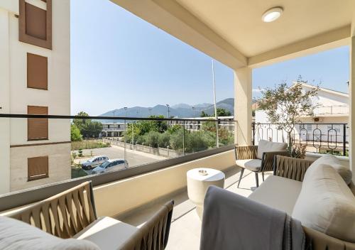 a balcony with couches and chairs and a large window at Dimitris Residence in Tivat