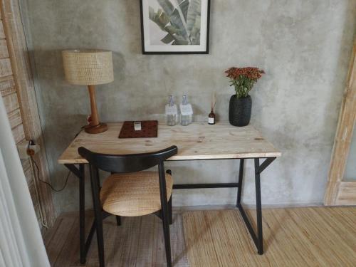 a desk with a chair and a lamp and a table at Sampian Cottages Bingin in Uluwatu