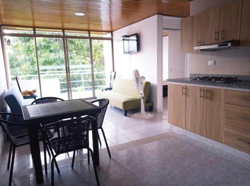 a kitchen with a table and chairs in a room at APARTAMENTO FAMILIAR MELGAR CON PISCINA ac in Melgar