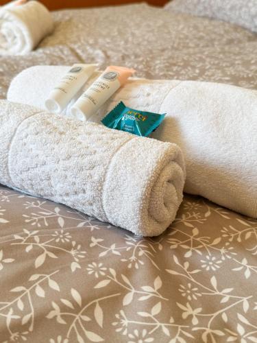 a rolled up towel and two toothbrushes on a bed at Penzion Čítkův Mlýn in Šluknov