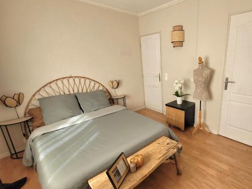 une chambre avec un grand lit avec une tête de lit en bois dans l'établissement Vacances cosy au soleil, à Fréjus