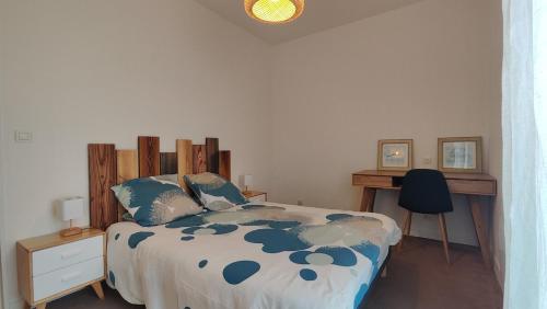 una camera da letto con un letto e una scrivania di Appartement proche de La Rochelle centre ad Aytré