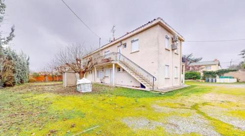 a house with a staircase on the side of it at Light T 3 air conditioning Two balconies Toulouse in Toulouse