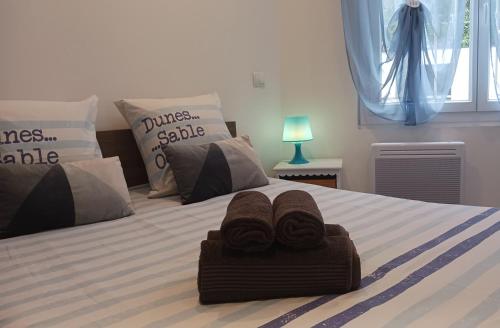 - une chambre avec 2 serviettes sur un lit dans l'établissement Cosy T2, Meublé de tourisme 3 étoiles, Parking fermé , 2Vélos, Wi-Fi, à Narbonne