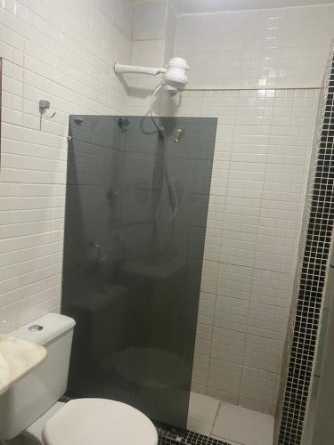 a bathroom with a shower with a toilet and a glass shower door at Flat Quintal293 in Recife
