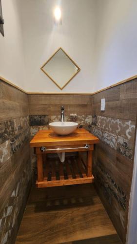 a bathroom with a sink on a wooden counter at Cabañas La Frontera in Villa General Belgrano