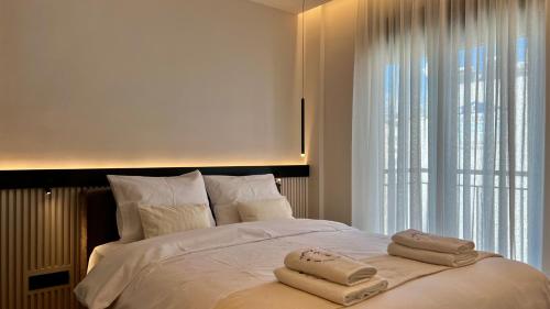 a bedroom with a large bed with towels on it at The First by 22 in Piraeus