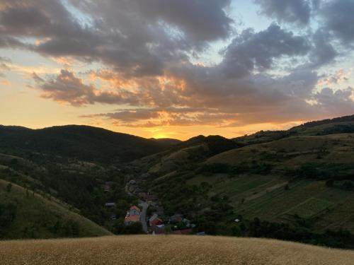 a view of a hill with the sunset in the background at Vila Bohemia in Sviniţa