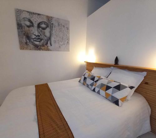 une chambre avec un lit avec un tableau sur le mur dans l'établissement Maison chez nous, à Saint-Priest