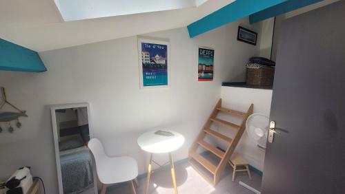 Cette chambre est dotée d'une table, de chaises et d'un plafond bleu. dans l'établissement La chambrée des bois, à Cadarsac